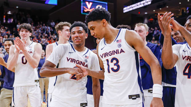 Reece Beekman and Ryan Dunn shake hands before Beekman is honored following his final Virginia men's basketball game at John Paul Jones Arena.